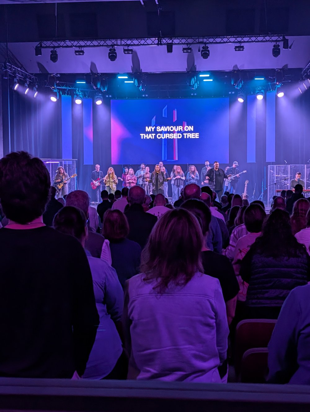 Worship night lighting design with a lit cross graphic on the video wall at North Way